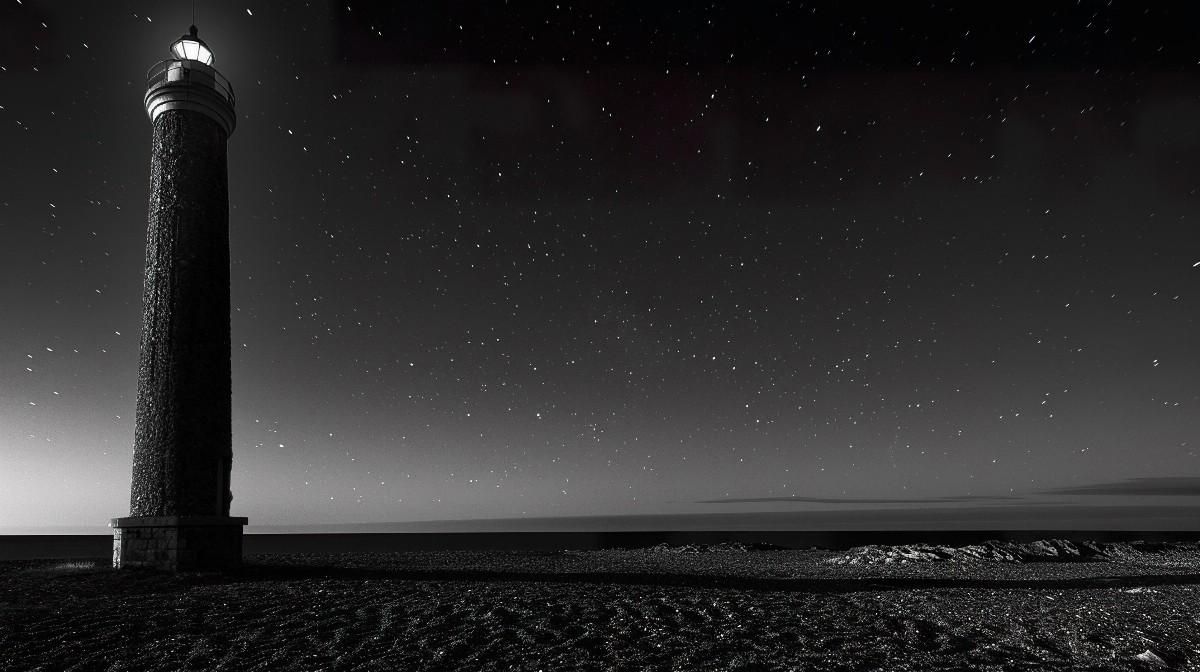 Abandoned lighthouse under starry sky